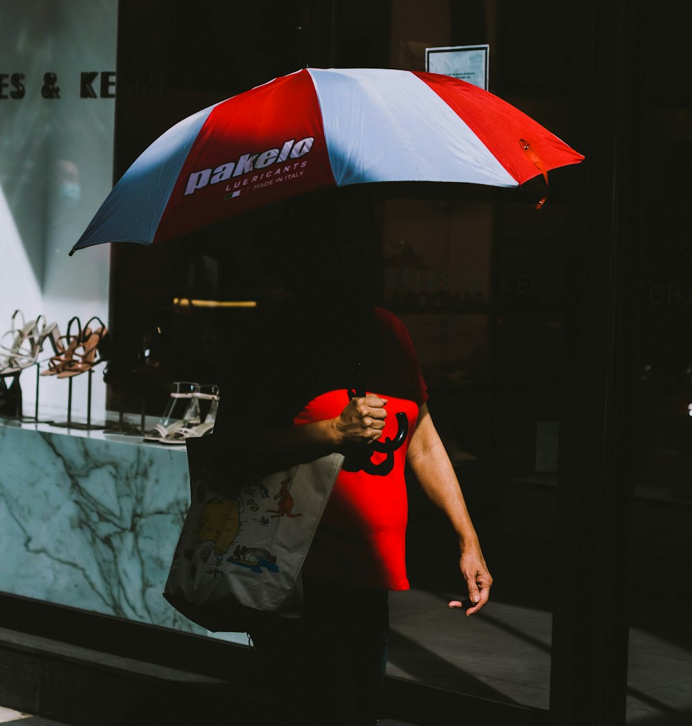 man in black t-shirt holding red umbrella