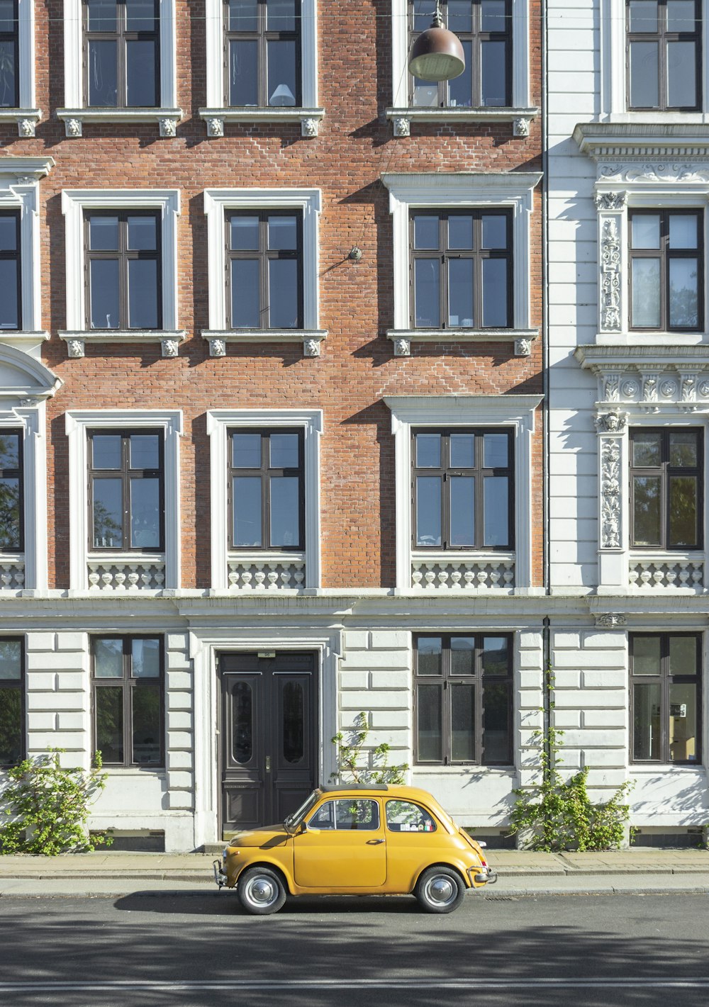 yellow car parked in front of brown and white concrete building