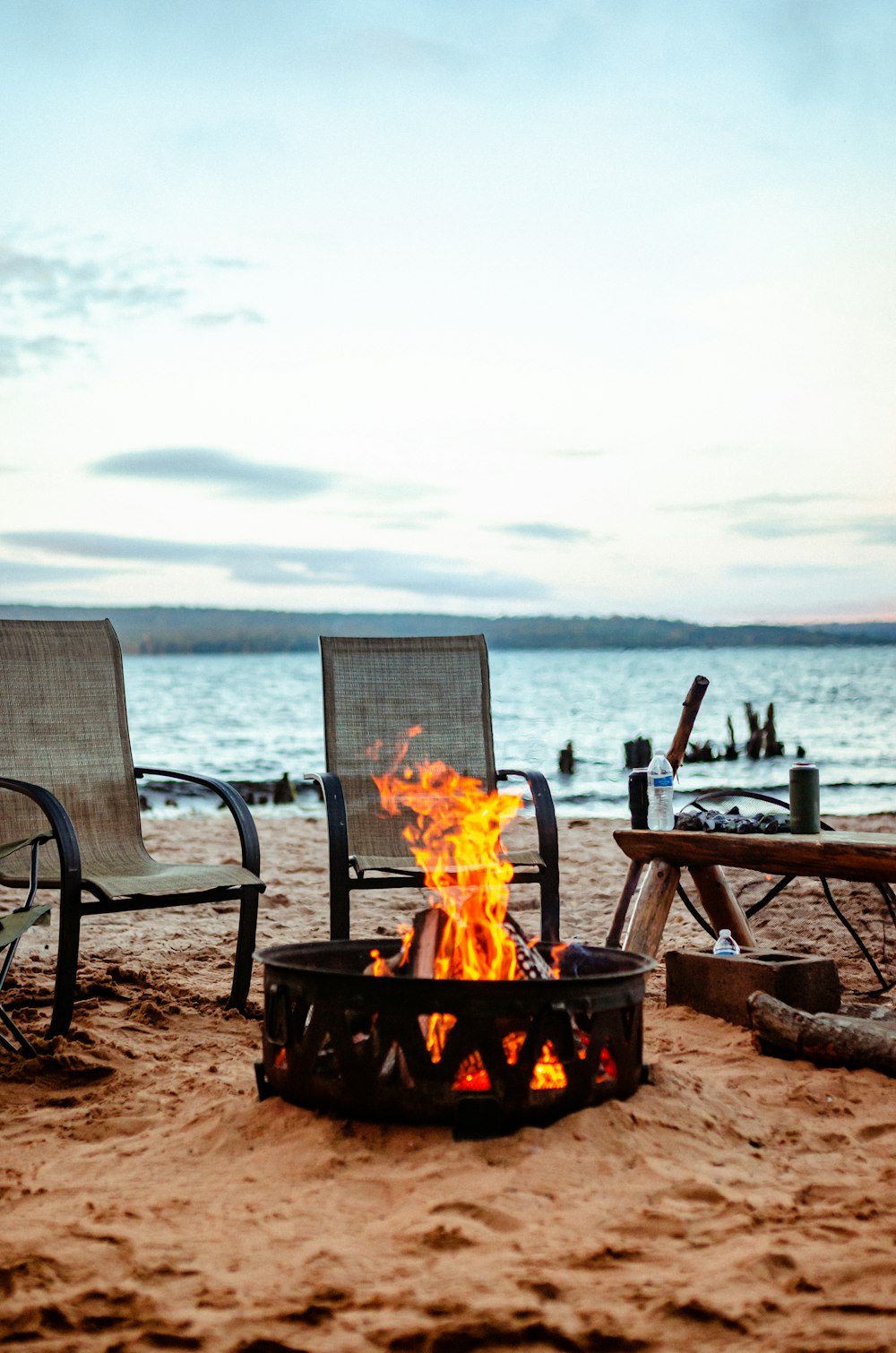 fire on fire pit near sea during daytime