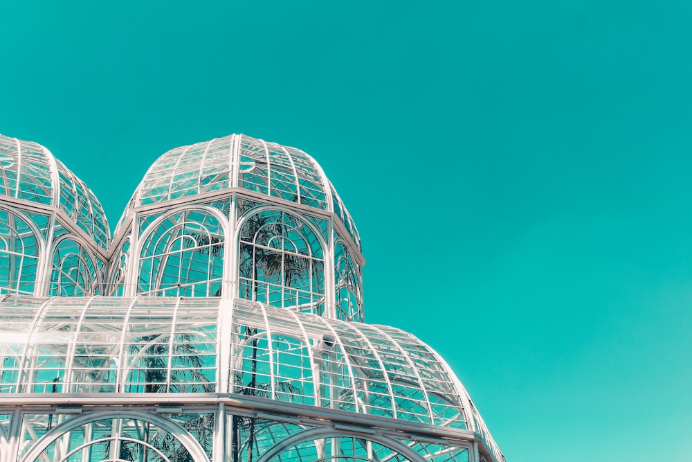 Weißes Metallrahmen-Glasgebäude unter blauem Himmel tagsüber