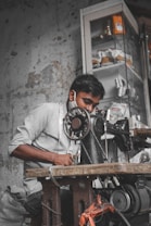 man in white crew neck t-shirt and blue denim jeans sitting on chair