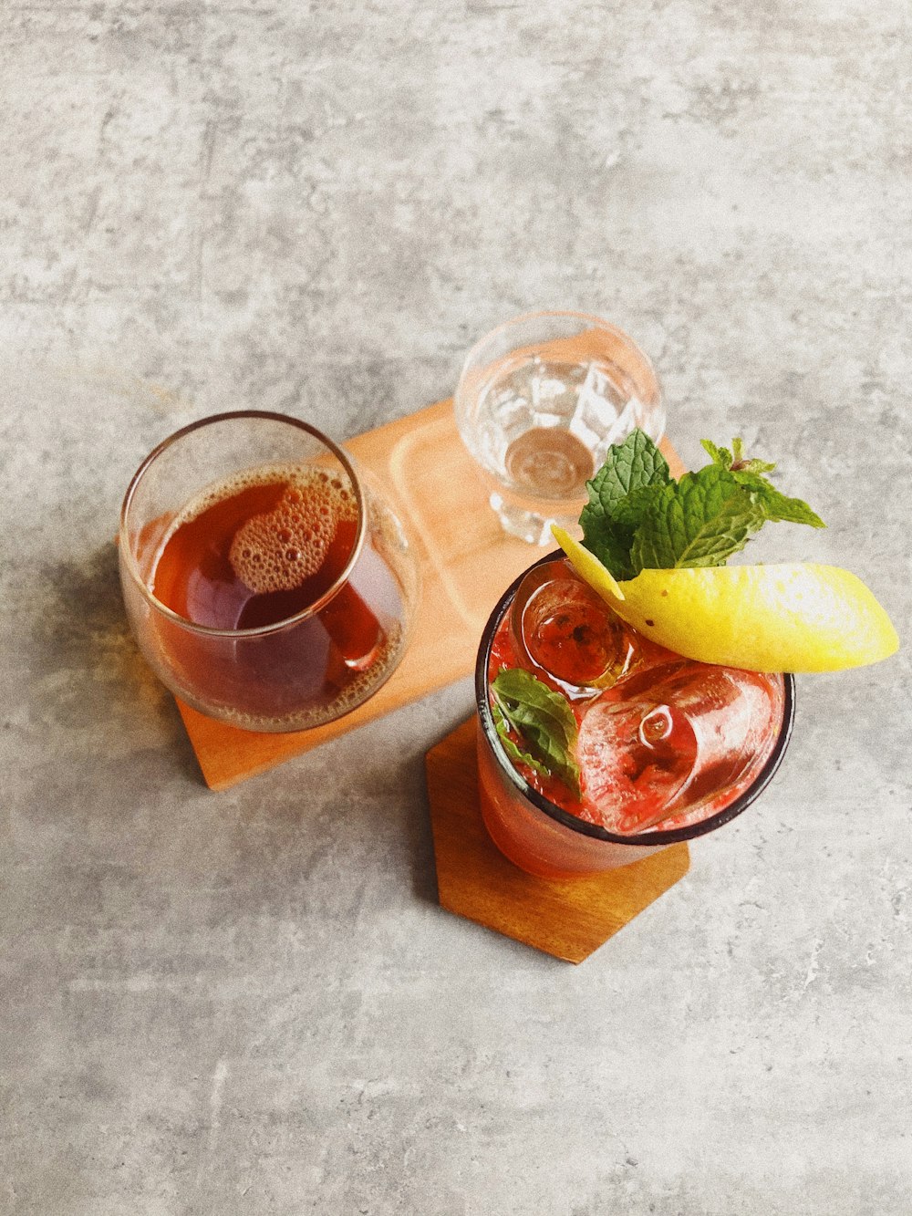 clear drinking glass with brown liquid and lemon