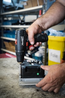 a man using a drill gun on a piece of metal