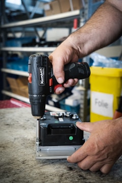 a man using a drill gun on a piece of metal
