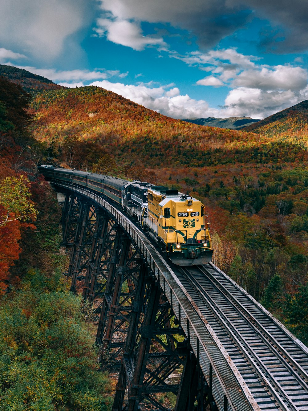 Train jaune sur les voies ferrées pendant la journée