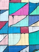 Hand-drawn street art blending bold geometric shapes with smooth wavy lines on a brick wall.
