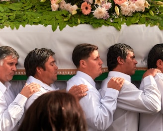 man in white dress shirt holding white flower bouquet