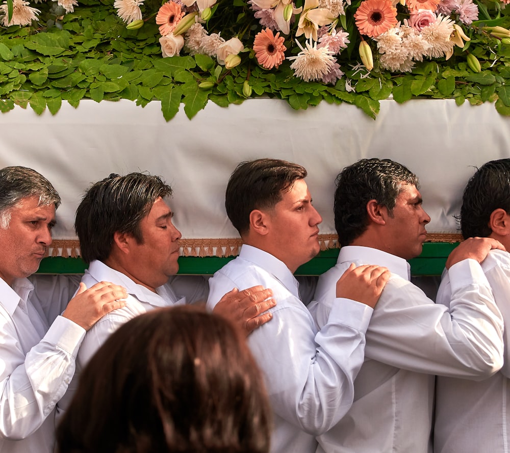 man in white dress shirt holding white flower bouquet