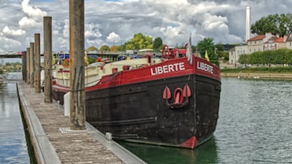The Libertas, a Kempenaar, sailing with its blue, white, and black colors reflecting on the water
