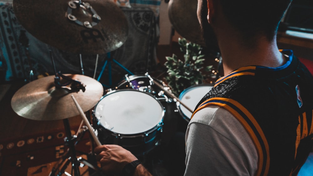 man in black shirt playing drum