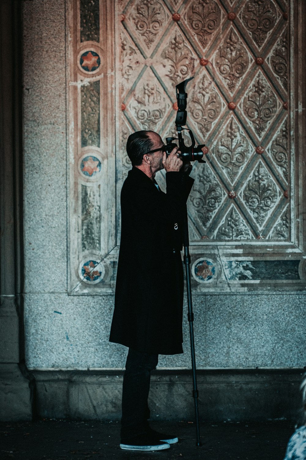 man in black robe holding black rifle