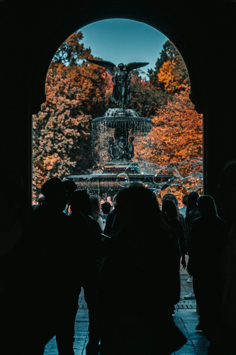 people standing near brown rock formation during nighttime