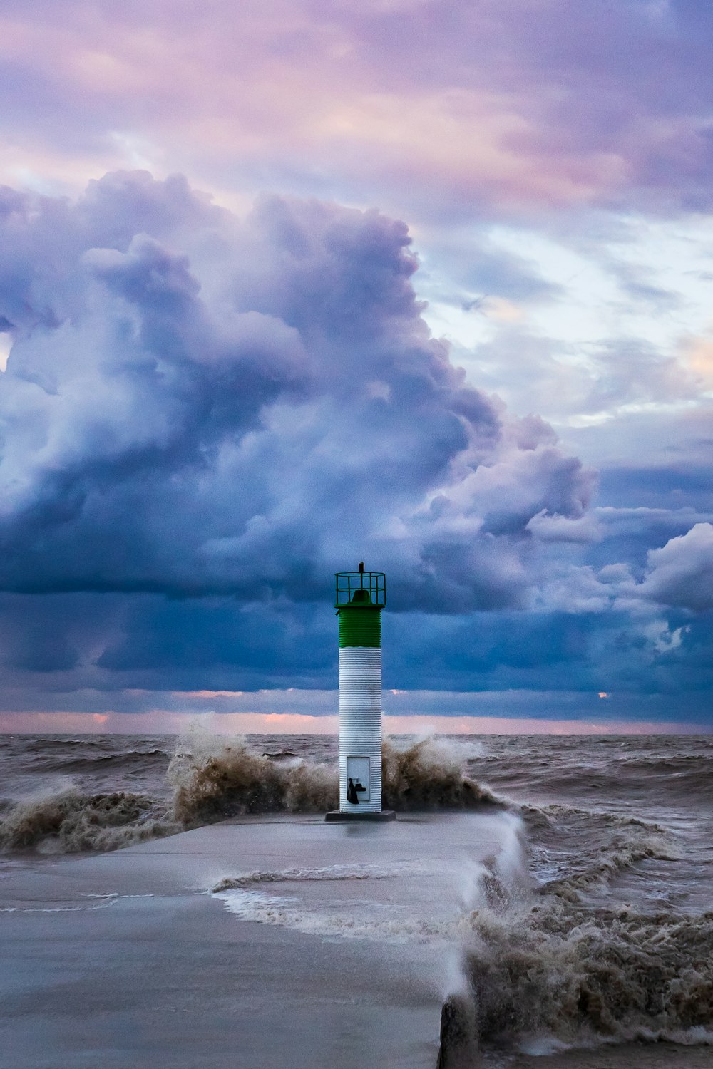 farol branco e verde sob nuvens brancas e céu azul durante o dia