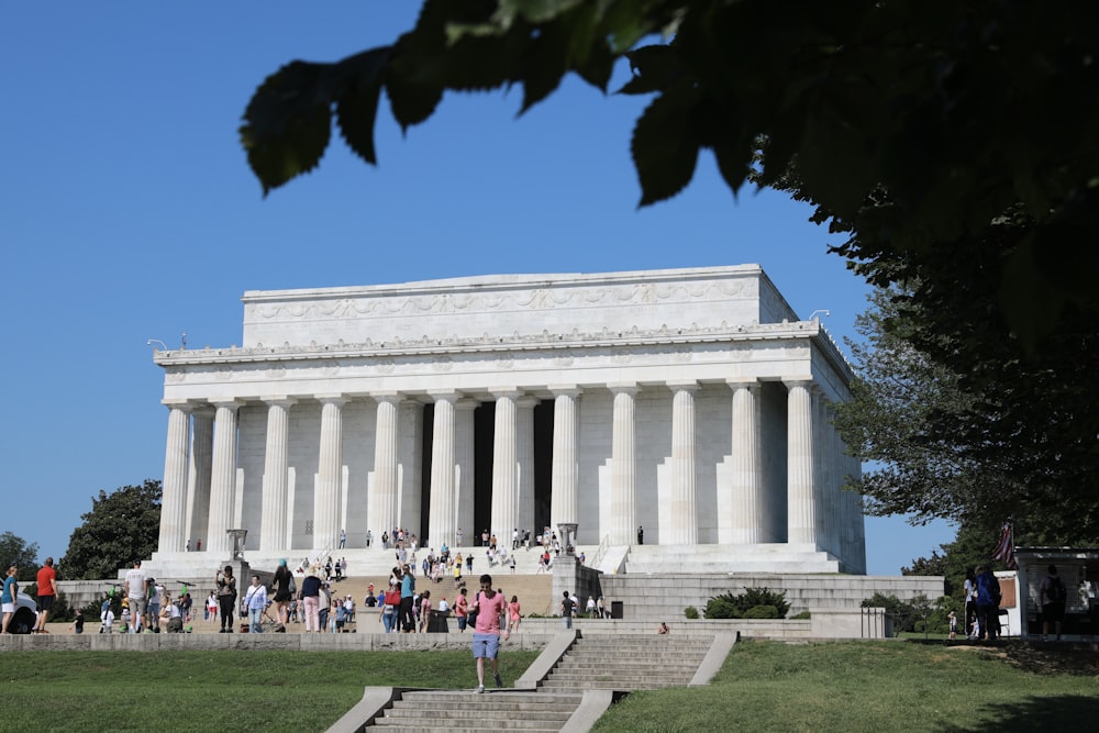 people walking in front of white concrete building during daytime