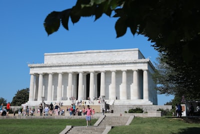 people walking in front of white concrete building during daytime lincoln memorial google meet background