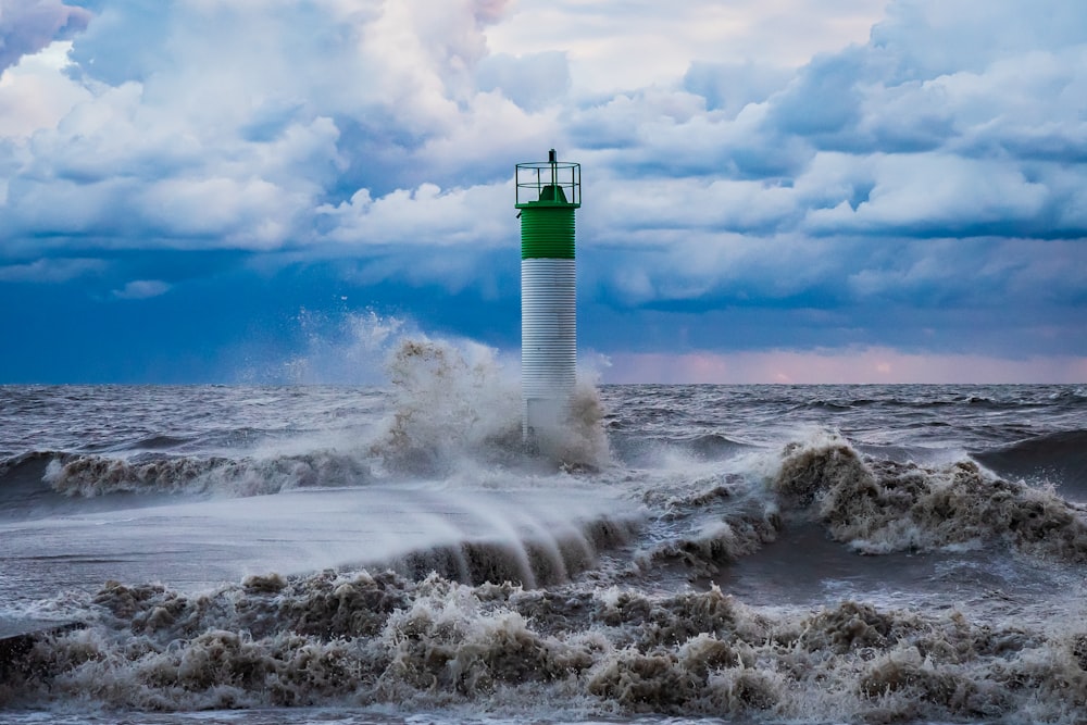 white and green lighthouse on white clouds during daytime