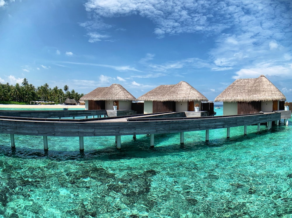 brown wooden house on blue body of water under blue sky during daytime