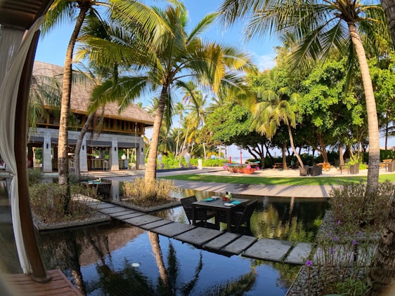 A serene resort nestled among lush greenery with cozy outdoor seating under soft sunlight.