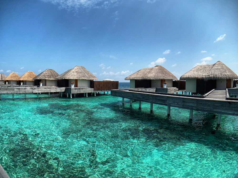 Casa de madera marrón en el cuerpo de agua bajo el cielo azul durante el día