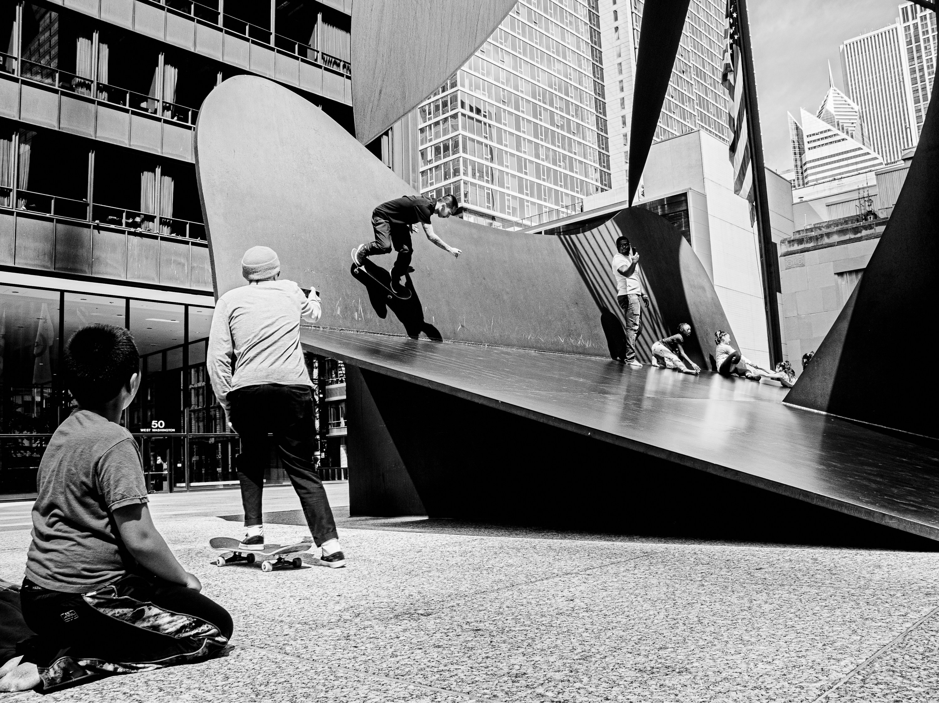 grayscale photo of man and woman walking on street
