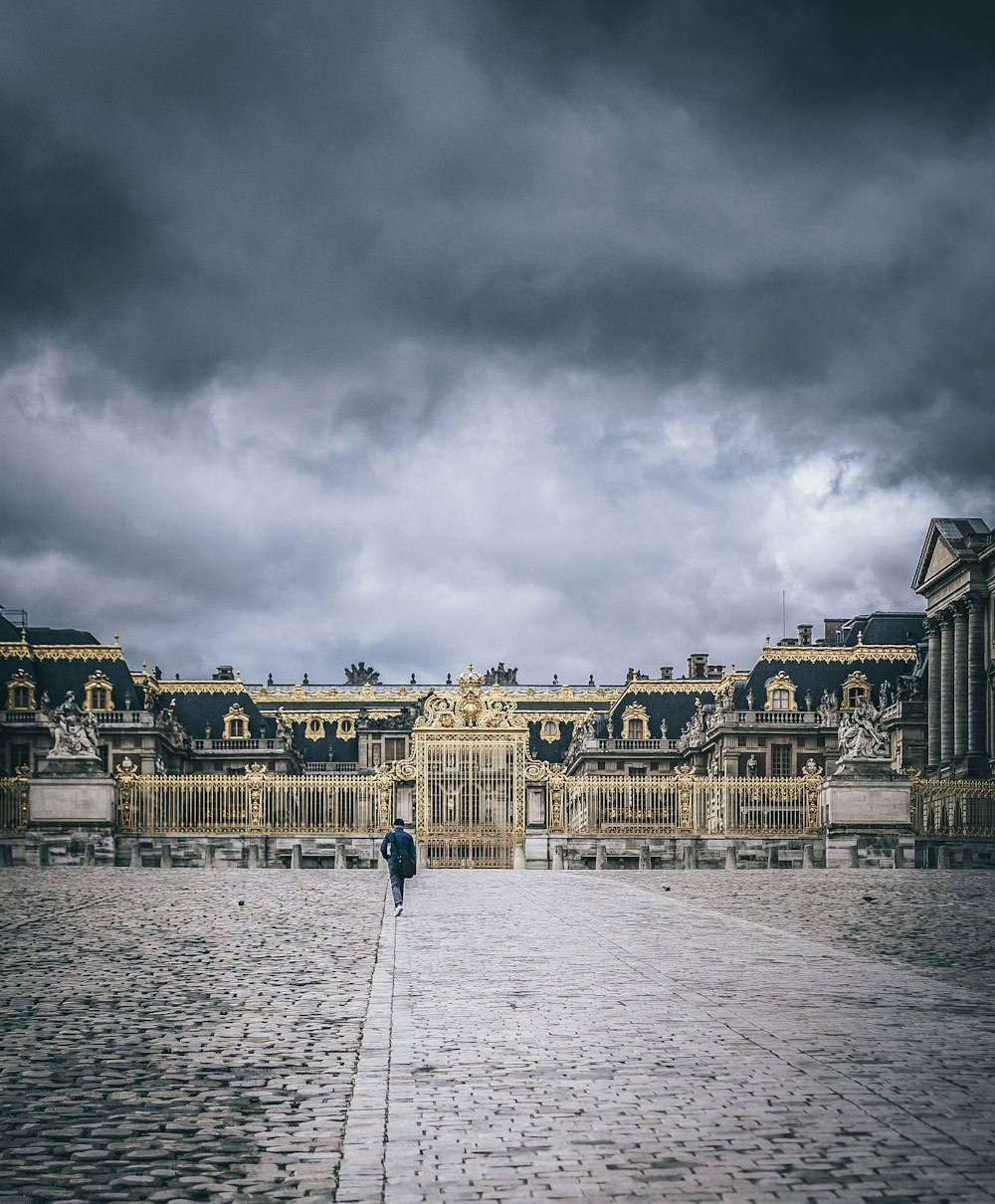 people walking on street near brown concrete building under gray clouds during daytime