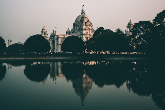 white concrete building near body of water during night time in Victoria Memorial India