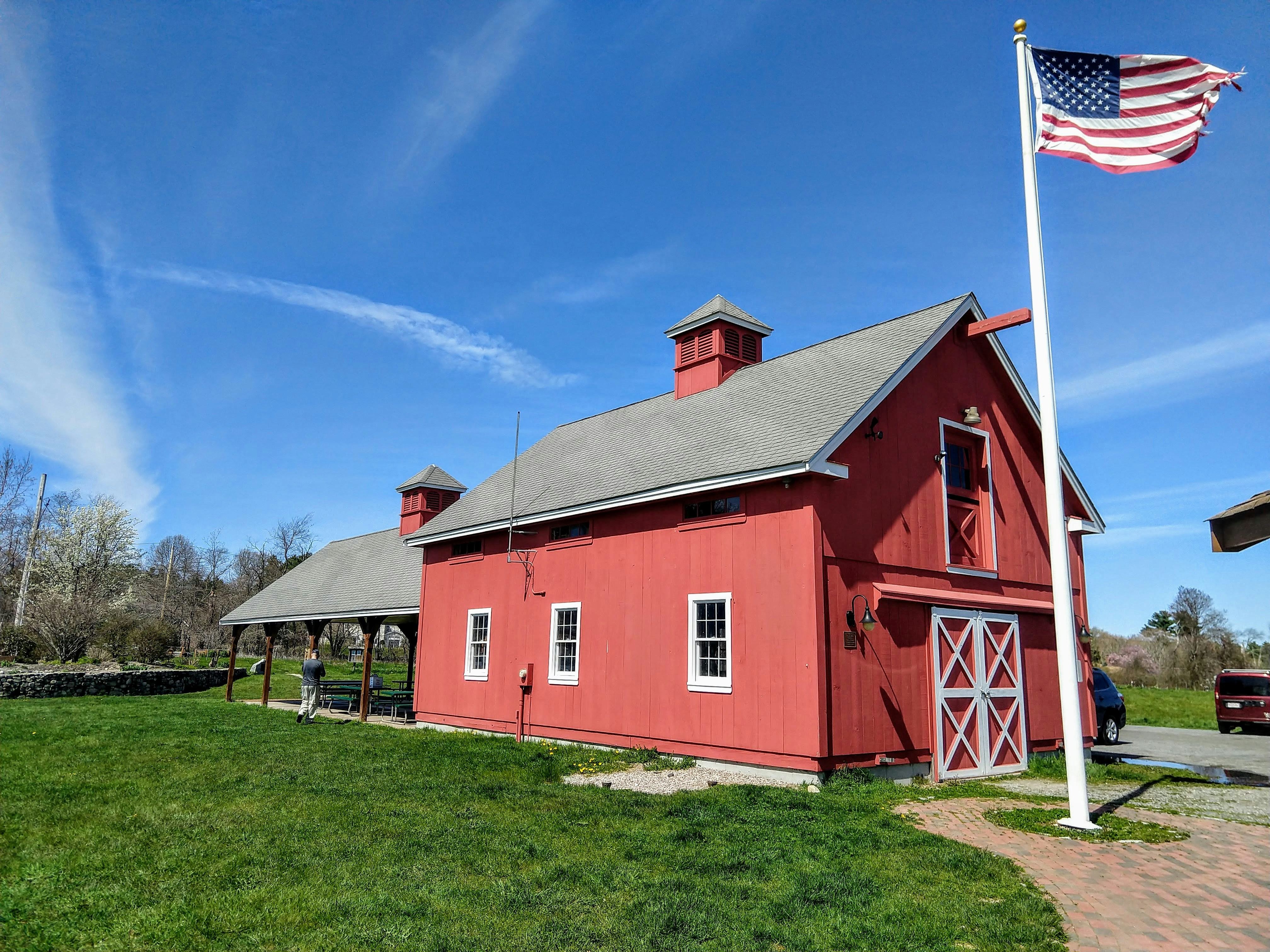 red and white wooden house on green grass field during daytime