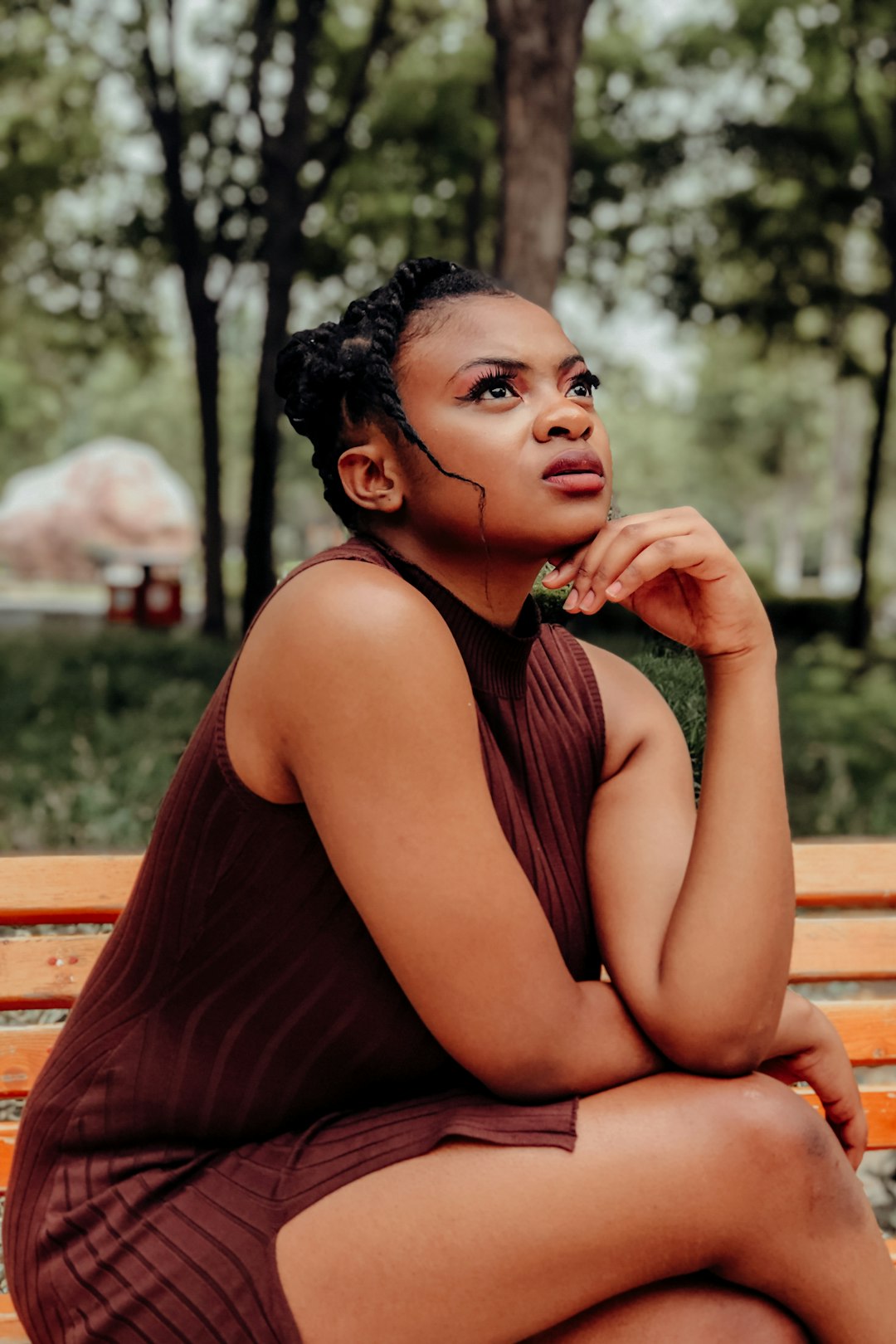 woman in black tank top sitting on brown wooden bench