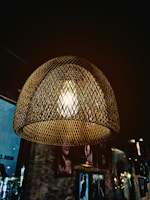 Finished metal lamp glowing softly in a warm, neutral-toned room.