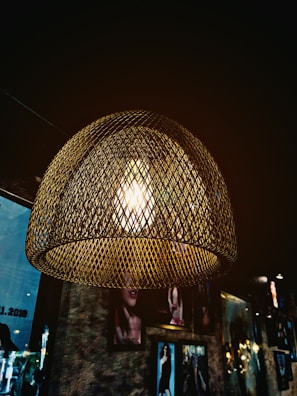 Finished metal lamp glowing softly in a warm, neutral-toned room.