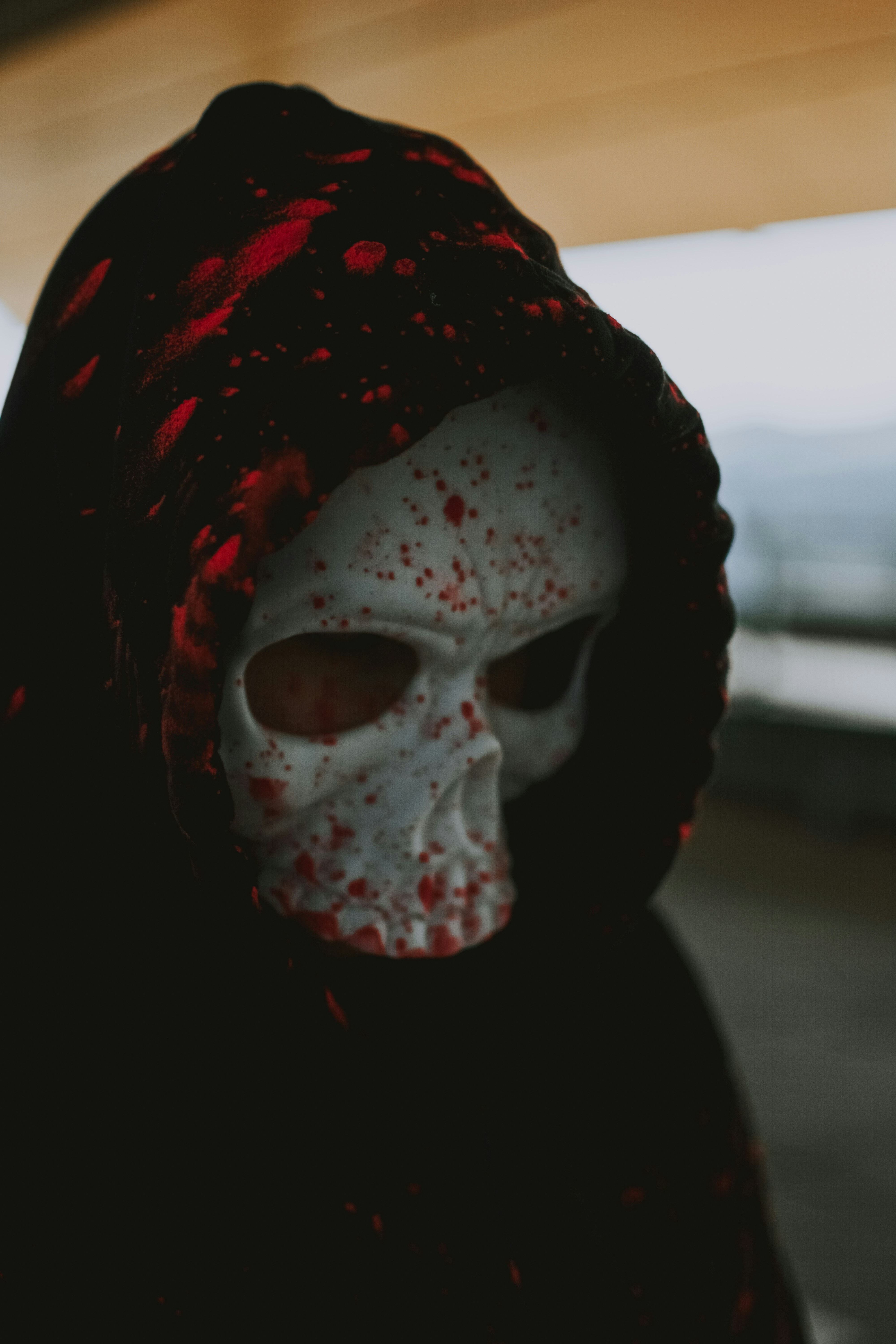 person wearing white mask and red and black scarf