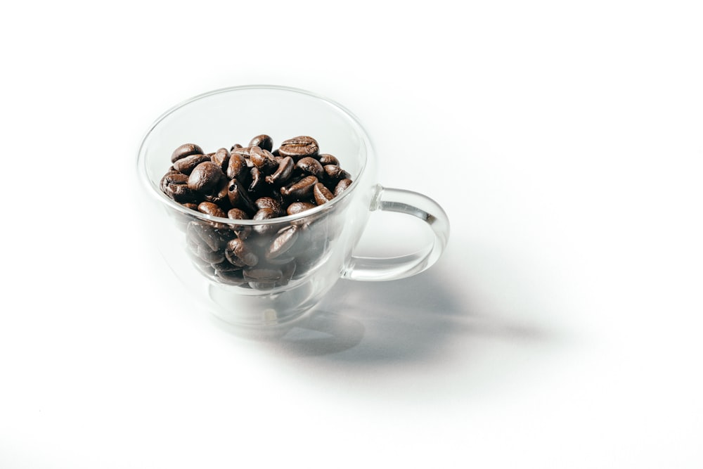 clear glass teacup with coffee beans