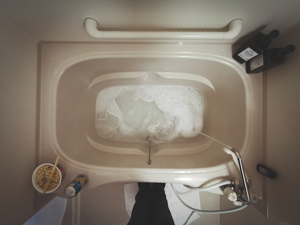 white ceramic bathtub with white plastic bag