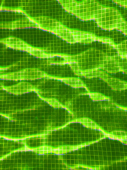 Bright green and purple neon checkerboard tile with a slight glow around the edges