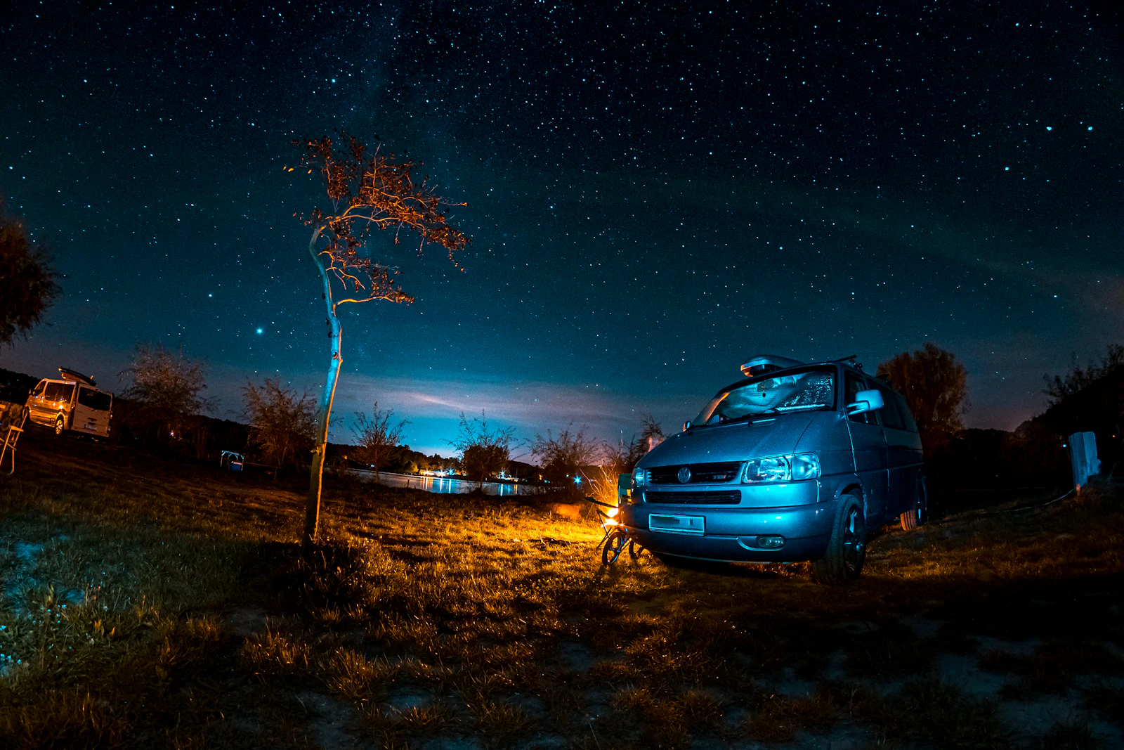 夜の草地に停まるグレーの SUV