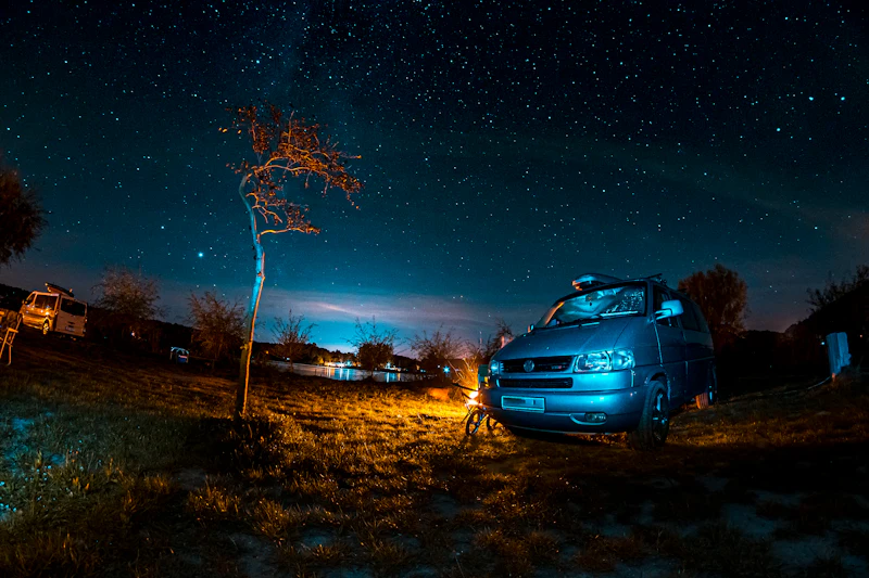 夜の草地に停まるグレーの SUV