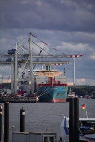 red and white cargo ship on dock during daytime