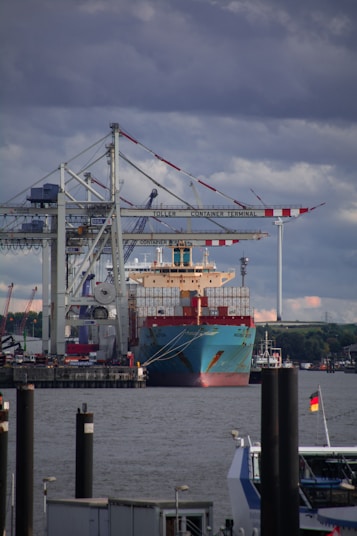 red and white cargo ship on dock during daytime