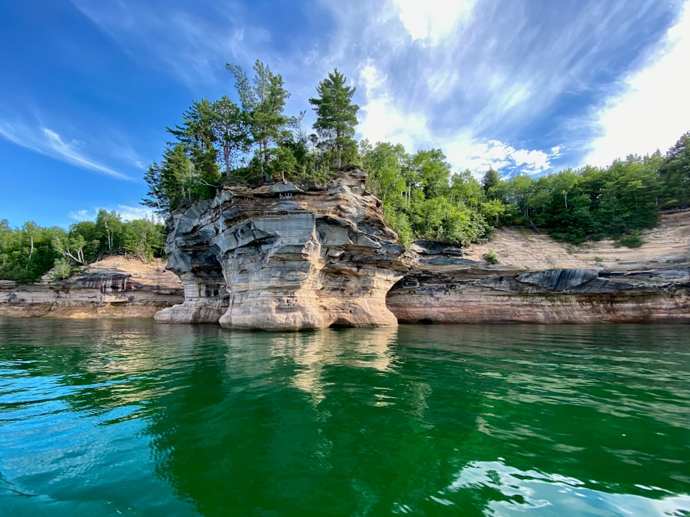 Grüne Bäume am Fluss unter blauem Himmel während des Tages