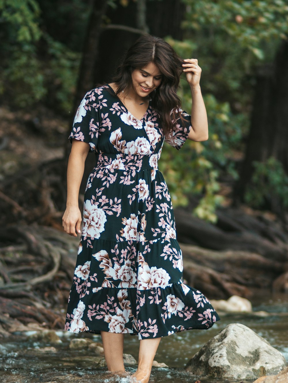 woman in black white and red floral dress standing on brown soil