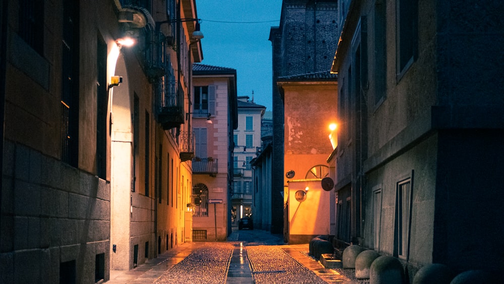 empty street between concrete buildings during night time