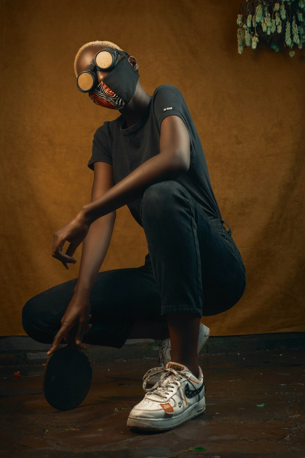 woman in black tank top and black pants sitting on brown wooden floor