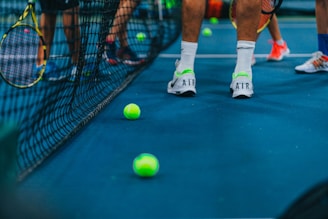 person in white nike sneakers standing on green tennis court