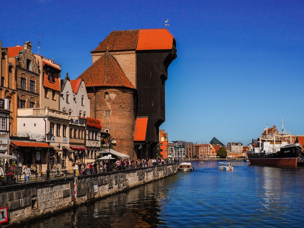 people walking on sidewalk near body of water during daytime