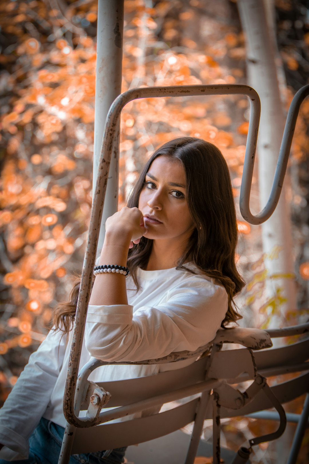 woman in white long sleeve shirt sitting on brown wooden bench