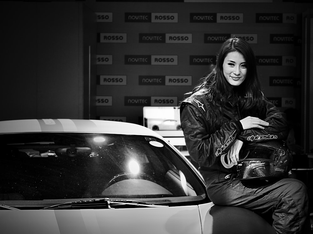 woman in black jacket sitting on car hood