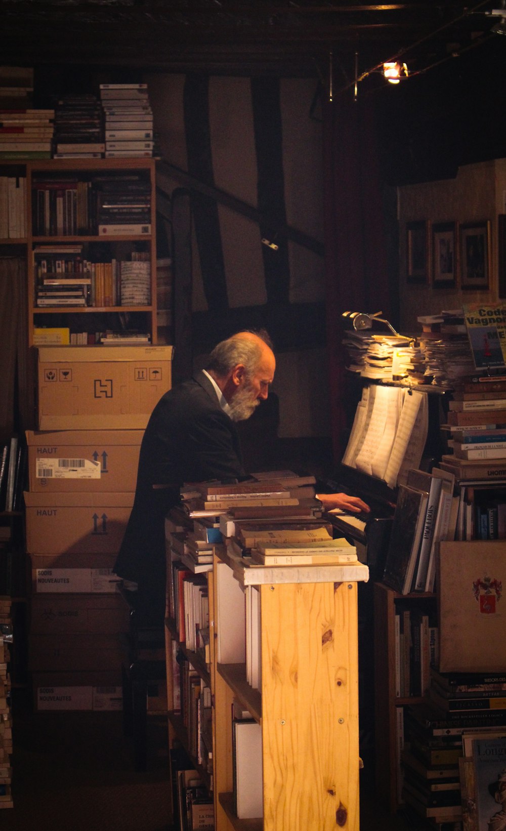 man in blue long sleeve shirt standing in front of books