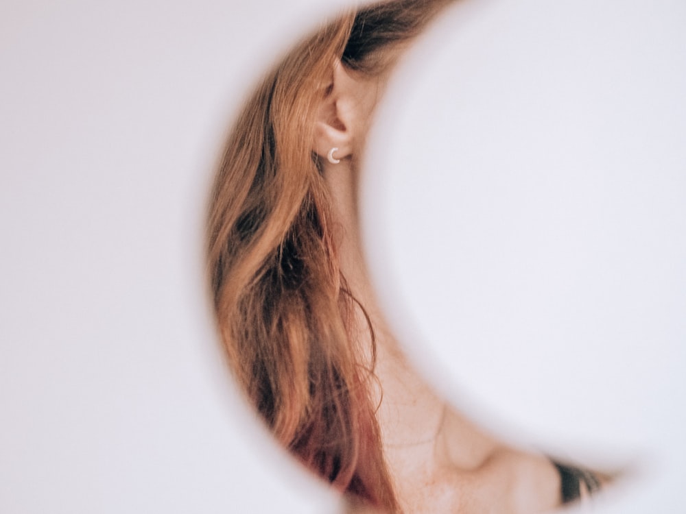 woman with blonde hair looking at the mirror