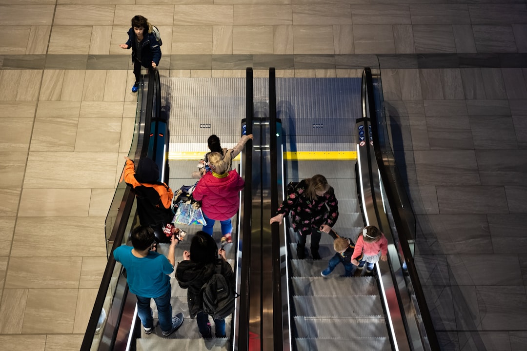 people walking on escalator inside building