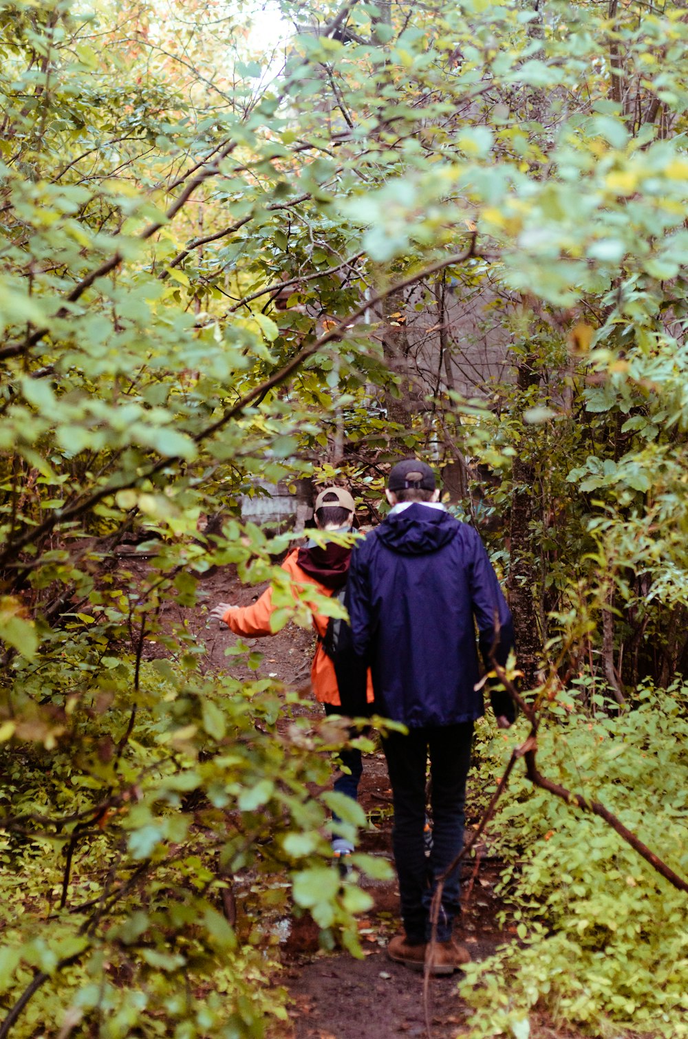 man in black jacket and black pants standing on forest during daytime